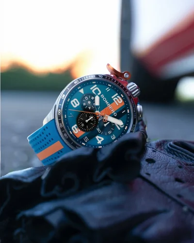 Srebrny zegarek męski Bomberg Watches z gumowym paskiem RACING 4.2 Blue / Orange 45MM